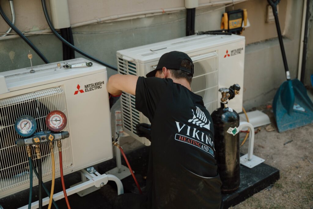 Viking Heating and Air technician servicing Mitsubishi mini-split condensers
