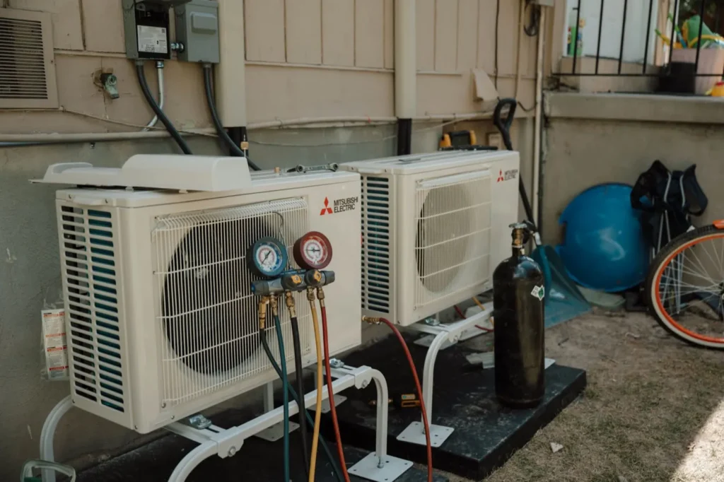 Two Mitsubishi Electric condensers installed side by side with refrigerant gauges attached