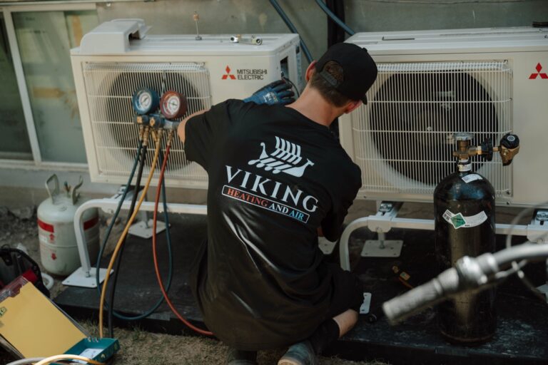 Viking Heating and Air technician servicing a Mitsubishi condenser unit