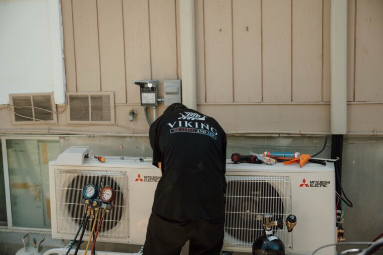 Viking Heating and Air technician servicing a Mitsubishi condenser unit