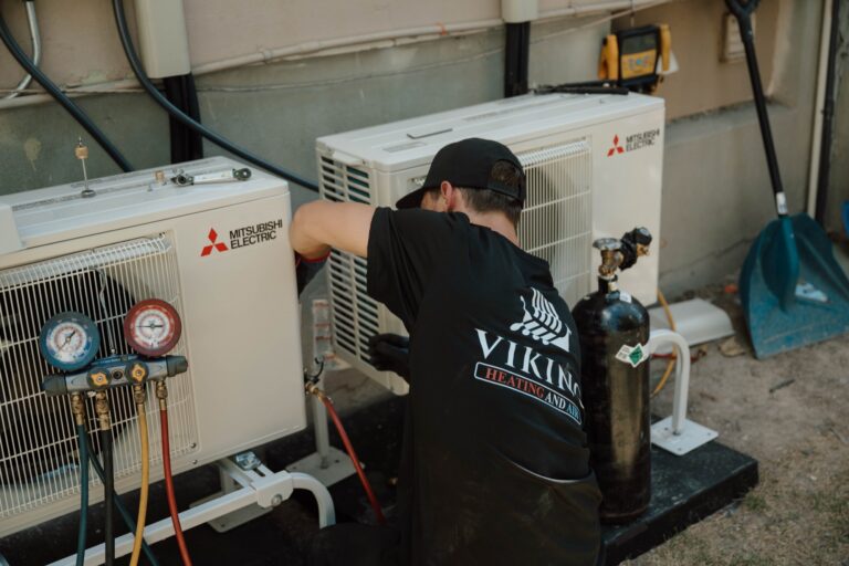 Viking Heating and Air technician servicing a Mitsubishi condenser unit