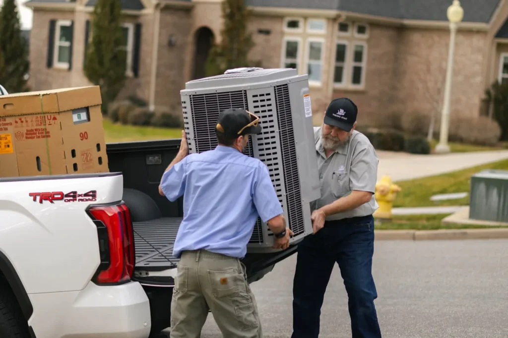 Viking Heating and Air technicians unloading a new AC condenser from a truck