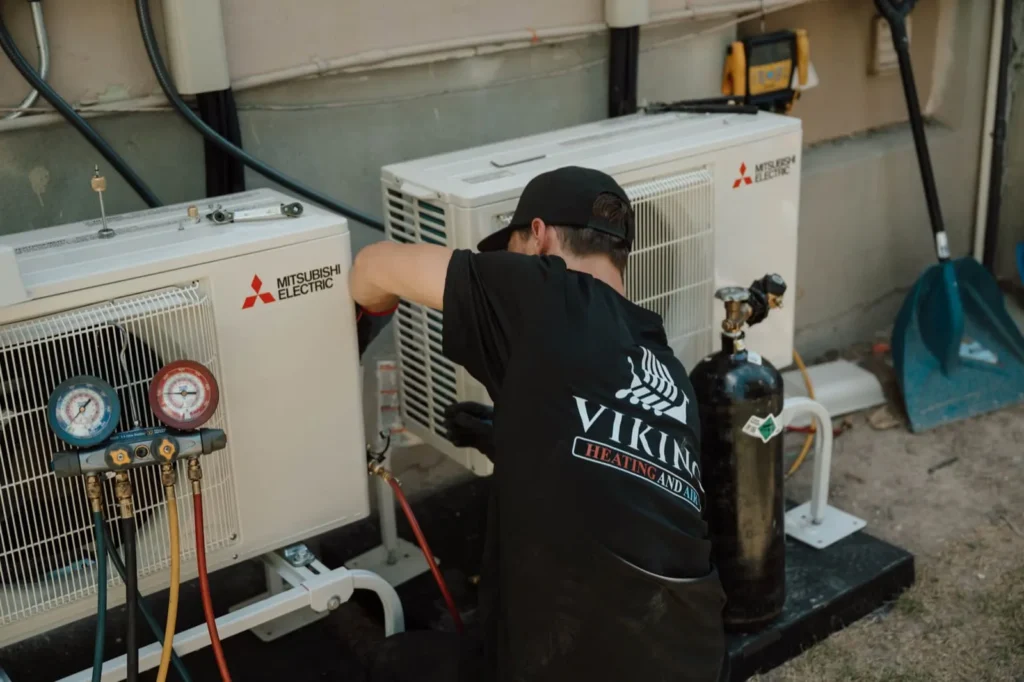 Viking Heating and Air technician installing Mitsubishi Electric condensers